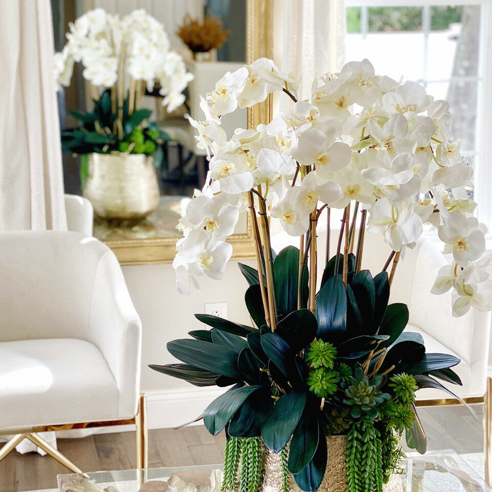 Vase Delaney doré avec plusieurs tiges d’orchidées Phalaenopsis et de plantes succulentes